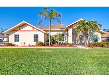 Charming single-story home featuring a well-manicured lawn, mature palm trees, and a welcoming facade under a clear blue sky at 1144 Hoover St, Nokomis, FL 34275