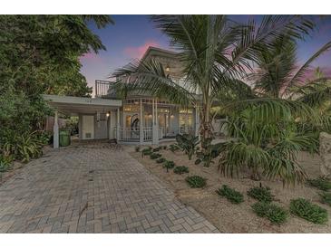 Charming two-story home with tropical landscaping, brick driveway, and covered parking at 160 Coolidge Dr, Sarasota, FL 34236
