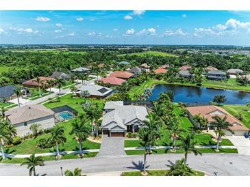 A beautiful aerial view of a neighborhood with lush landscaping and a serene pond at 303 Cockle Shell Loop, Apollo Beach, FL 33572
