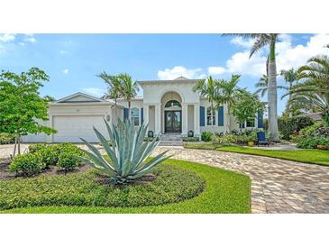 Elegant home featuring manicured landscaping, a brick driveway, and stately architectural details at 413 Partridge Cir, Sarasota, FL 34236
