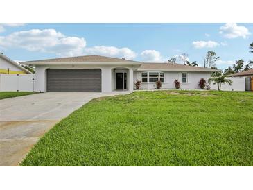 Charming single-story home with a well-maintained lawn, gray garage door, and beautiful landscaping at 4344 Bent Tree Blvd, Sarasota, FL 34241
