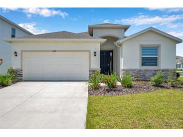 Inviting home featuring stone accents, a two-car garage, and a modern exterior at 4405 Weathered Moss Gln, Palmetto, FL 34221