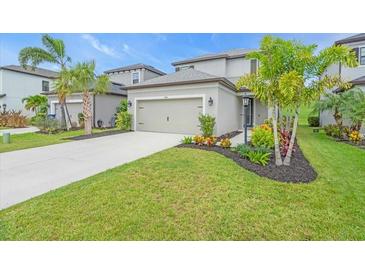 Charming home with landscaped front yard, healthy green lawn, and concrete driveway leading to a two-car garage at 5540 Summit Gln, Bradenton, FL 34203