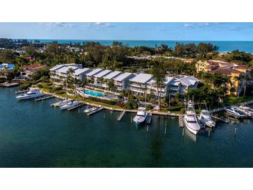 Waterfront condos with boat docks, a swimming pool, and lush landscaping offer luxurious coastal living at 615 Dream Island Pl # 105, Longboat Key, FL 34228