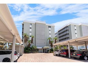 Exterior of complex with brick parking area under carports and well maintained landscaping at 6312 Midnight Pass Rd # 102S, Sarasota, FL 34242