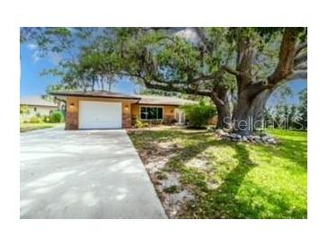 Charming single-story home with a well-maintained lawn and a large, mature tree in the front yard at 760 Azure Rd, Venice, FL 34293