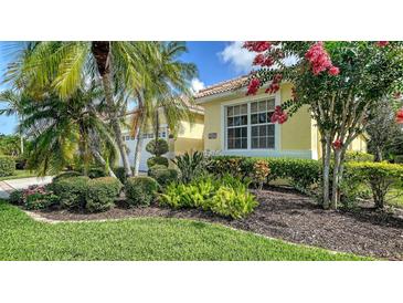 Beautiful front yard features mature landscaping and a well-maintained lawn at 8183 Nice Way, Sarasota, FL 34238