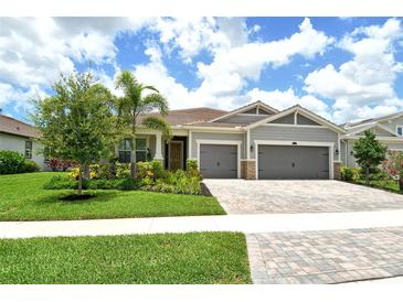 Charming single-Gathering home featuring a well-manicured lawn, mature landscaping, and a two-car garage at 8668 Sundance Loop, Sarasota, FL 34238