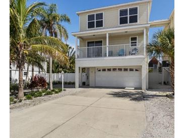 Charming two-story home featuring a spacious garage, balcony, and meticulously landscaped yard with mature palm trees at 123 52Nd St # B, Bradenton Beach, FL 34217
