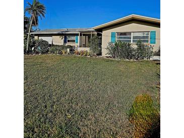 Charming home with large front yard and eye-catching blue shutters at 134 Gulfview Rd, Punta Gorda, FL 33950