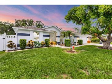 Charming single-story home with manicured lawn, mature trees, and attractive landscaping at 2381 Appaloosa Cir, Sarasota, FL 34240