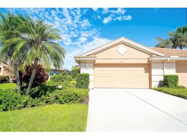 Inviting one-story home features a lush landscaped front yard with a private two-car garage at 362 Fairway Isles Ln, Bradenton, FL 34212