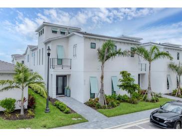 Beautiful three-story home with modern architectural details and lush tropical landscaping at 6028 Red Mangrove Ln, Bradenton, FL 34210