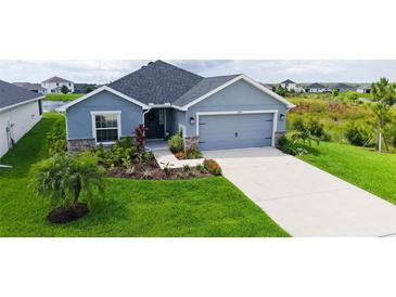 Charming single Gathering home featuring a two-car garage and a beautifully landscaped front yard at 6435 165Th E Dr, Parrish, FL 34219