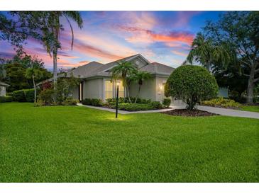 Charming single-story home featuring a well-manicured lawn, mature landscaping, and inviting curb appeal at 7424 Sea Island Ln, Bradenton, FL 34201