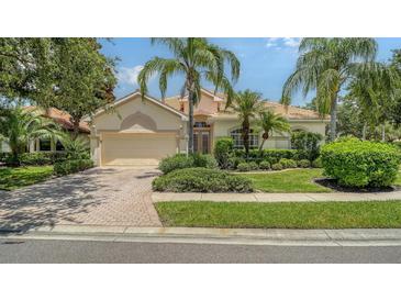 Charming single-story home boasts mature landscaping, a tile roof, and a brick driveway at 7717 Us Open Loop, Lakewood Ranch, FL 34202