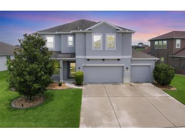 Beautiful two-story home featuring a three-car garage and manicured lawn at 7930 111Th Ter E, Parrish, FL 34219
