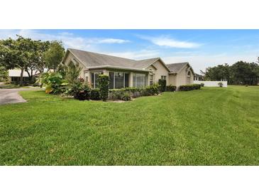 Single-story home with lush landscaping, light tan exterior, and well-manicured lawn at 1112 Golfview Woods Dr # 1112, Sun City Center, FL 33573