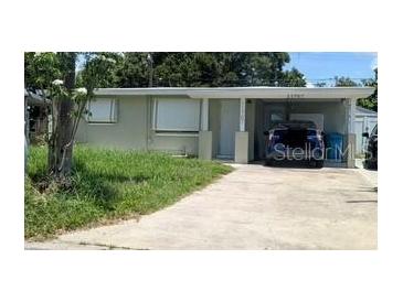 Charming single-story home with a covered parking area, a well-maintained lawn, and mature trees at 11707 104Th St, Largo, FL 33773