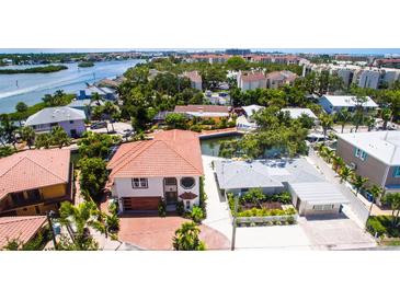 Charming waterfront home with a red tile roof, mature trees, and lush landscaping at 1240 Solitude Ln, Sarasota, FL 34242