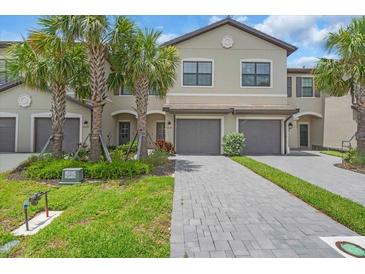 Charming two-story townhome with a two-car garage, lush landscaping, and a welcoming entryway at 15131 Sunny Day Dr, Bradenton, FL 34211