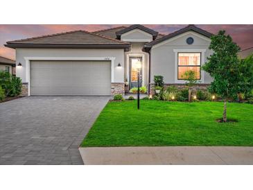 Charming single-Gathering home with a well-maintained lawn, stone accents, and a two-car garage at 15716 Barefoot Beach Dr, Bradenton, FL 34211