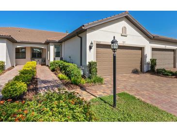 Charming home with a two-car garage, brick driveway, and well-maintained landscaping at 17612 Northwood St, Lakewood Ranch, FL 34202