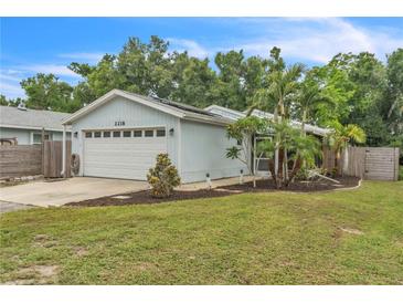 Charming single-story home featuring a two-car garage, well-maintained lawn, and mature landscaping at 2218 Woodmere Rd, Venice, FL 34293