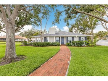 Charming single-story home with a brick walkway and a well-manicured lawn at 2401 Riverview Blvd, Bradenton, FL 34205