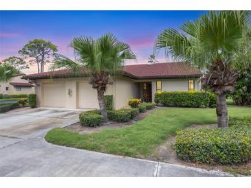 Charming single-story home featuring a well-manicured lawn, mature palm trees, and a two-car garage at 3617 Yellow Pine Ct # 144, Sarasota, FL 34238
