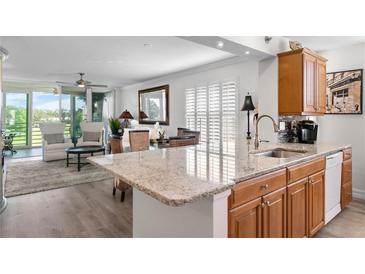 Bright kitchen featuring granite countertops, stainless sink and appliances, and open to a stylishly furnished living area at 4440 Fairways Blvd # 310, Bradenton, FL 34209