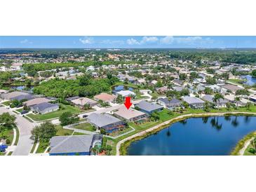 Beautiful aerial view of a property on the lake with a screen enclosed pool and well maintained landscaping at 4531 Useppa Dr, Bradenton, FL 34203