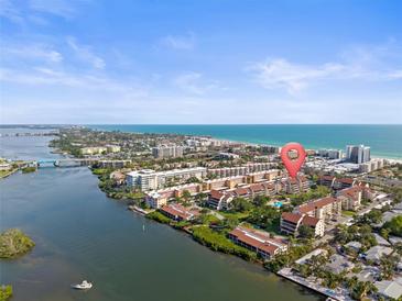 Beautiful aerial view of a waterfront condo community near the ocean under a bright, blue sky at 6265 Midnight Pass Rd # 205, Sarasota, FL 34242