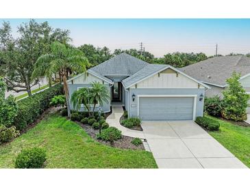 Charming single-story home featuring a well-manicured lawn, landscaped garden beds, and a two-car garage at 6516 Palm Leaf Ct, Sarasota, FL 34243