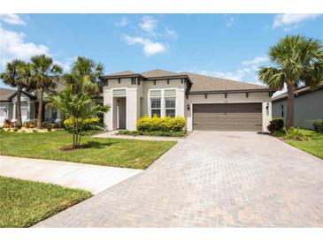 Stunning single-story home with a two-car garage, landscaped front yard, and beautiful palm trees at 918 Fernleaf Run, Bradenton, FL 34212