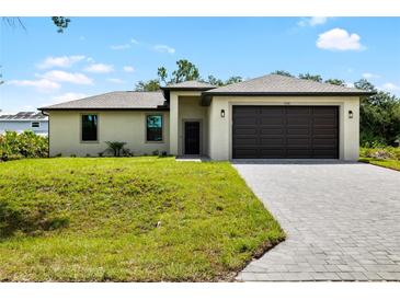 Charming one-story home featuring a two-car garage, neutral color palette, and well-manicured lawn with paver driveway at 1532 Maricopa Rd, North Port, FL 34287