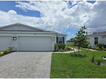 Charming single-story home featuring a paver driveway, two-car garage, and well-maintained landscaping at 16048 Ivy Ridge Ct, Port Charlotte, FL 33953