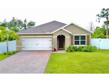 Charming one-story home features manicured lawn, brick driveway, and attached two-car garage at 1646 Pierpoint St, North Port, FL 34288