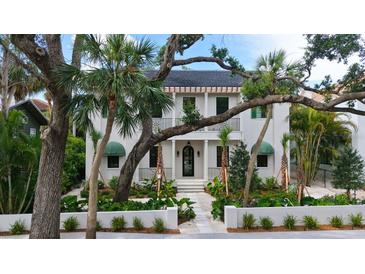 Stunning two-story home featuring lush landscaping, a black balcony, and a charming front entrance at 1658 Bonita Ln, Sarasota, FL 34239