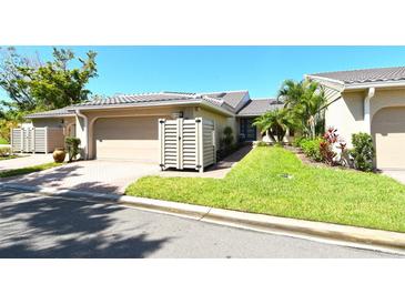 Charming single-story home with a well-manicured lawn, tile roof, and two-car garage at 2103 Harbourside Dr # 1102, Longboat Key, FL 34228