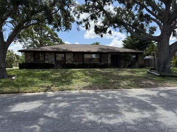 Charming stone-faced home with mature trees and a well-maintained front yard at 211 55Th Nw St, Bradenton, FL 34209