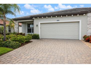 Attractive home featuring a two car garage, paver driveway and lush landscaping at 2316 Springhaven Ln, Lakewood Ranch, FL 34211