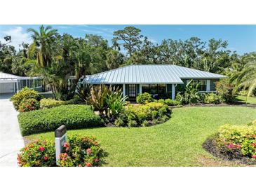 Charming home with a metal roof and meticulously landscaped front yard, exuding curb appeal at 2321 Milford Cir, Sarasota, FL 34239