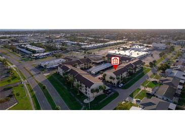 Aerial view of a complex with covered parking, green spaces, and easy access to nearby amenities at 2395 Harbor Blvd # 314, Port Charlotte, FL 33952