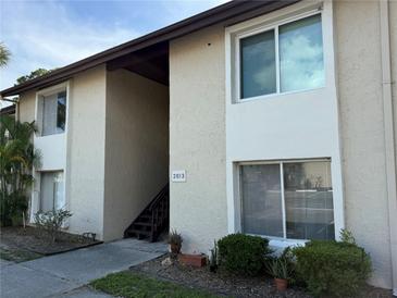 Exterior of the two-story building with well-maintained landscaping and visible unit number at 2613 Pine Lake Ter # C, Sarasota, FL 34237