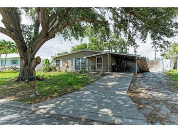 Charming single-story home featuring a covered porch and driveway under a large tree canopy at 3307 Miami Pl, Bradenton, FL 34207