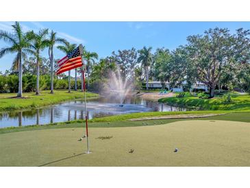 Beautiful Florida home featuring a putting green, pond with fountain, and an American flag waving in the breeze at 5311 36Th E Ave, Palmetto, FL 34221