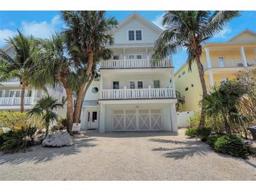 Charming multi-story beach house with dual balconies, garage, and tropical landscaping at 538 Canal Rd, Sarasota, FL 34242