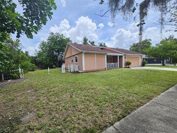 Side view of home with a lush lawn, white picket fence, and mature trees at 6305 Bikini Rd, Sarasota, FL 34241
