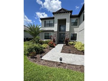 Elegant home features a stone facade, well-manicured lawn, and inviting walkway leading to the front door at 16231 Tradewind Ter, Bradenton, FL 34211